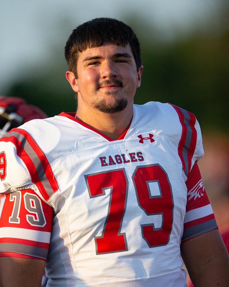 "Eagles player number 79 poses in uniform during a golden-hour football practice session"