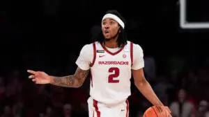 "Arkansas Razorbacks guard, wearing jersey number 2, directs teammates during a high-stakes game"