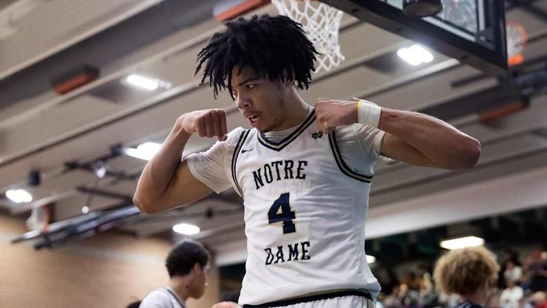 "Notre Dame basketball player number 4 flexes muscles during a competitive game moment"