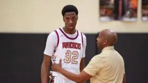 "Mavericks basketball player number 32 receives guidance from coach during a strategy discussion in the gym"