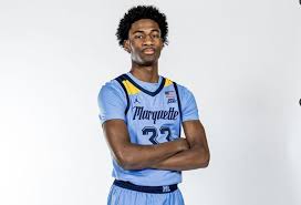 "Marquette basketball player, number 23, poses confidently in team uniform during media day"