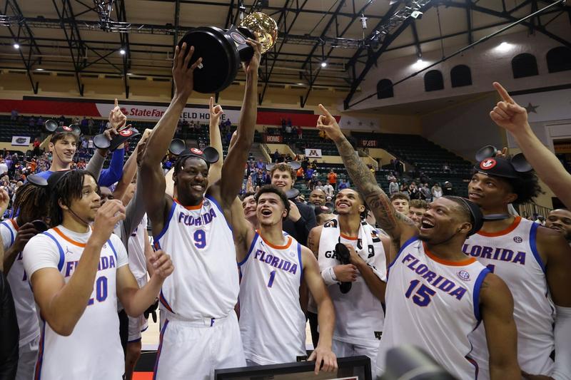"Florida Gators celebrating their NCAA championship victory with the trophy at a court event."