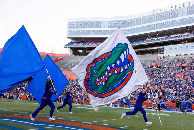 "Florida Gators enthusiasts wave team flags at a home game celebrating the Florida 2025 win total."