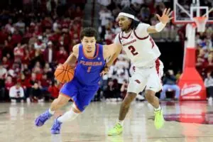 "Clayton dribbles past a defender in a Florida Gators vs. Arkansas Razorbacks basketball game, highlighting his NBA draft projection."